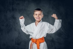 Preschooler boy dressed in a white karate kimono.